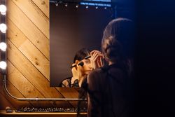 Beautiful brunette female in peignoir applying makeup