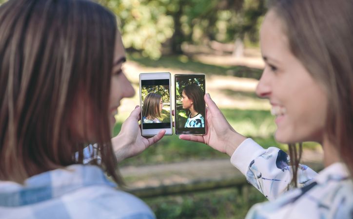 Women showing smartphones with side view portraits photos