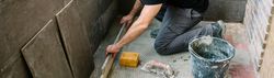 Bricklayer checking floor with a level