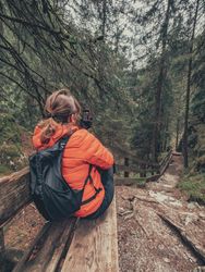 Tourist resting with smartphone on hiking path