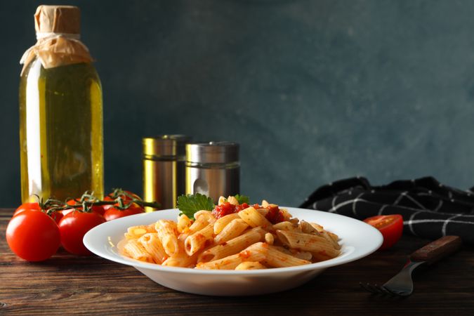 Composition with plate of tasty pasta on wooden background. Cooking pasta