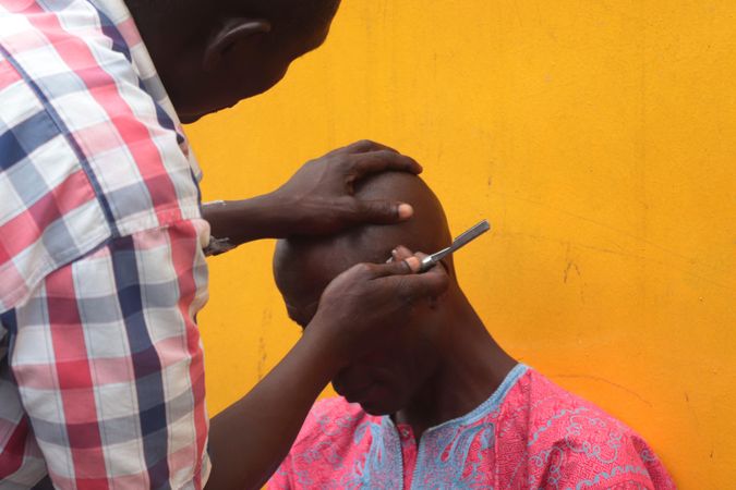 Barber shaving man's head