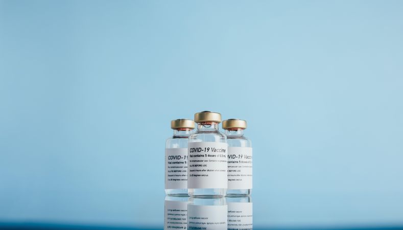 Covid-19 vaccine vials on reflective surface