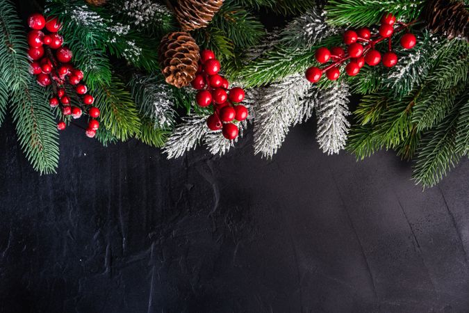 Christmas frame with holly on concrete background