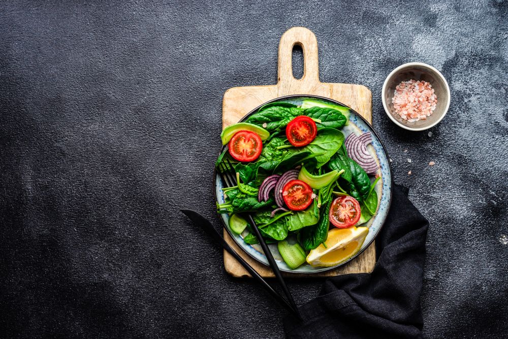 Top view of spinach salad with cherry tomatoes and cucumber