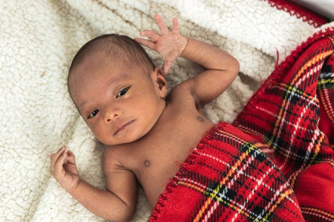 Newborn baby on soft tartan blanket