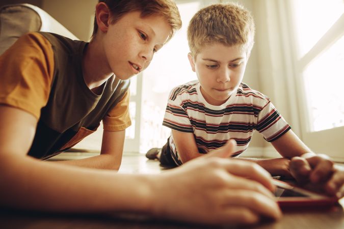 Two boys playing a game on tablet pc with great interest