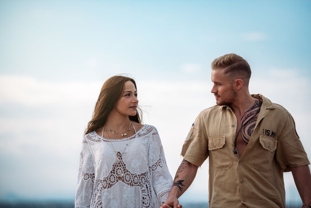 adorable couple walking on an amazing beach holding hands