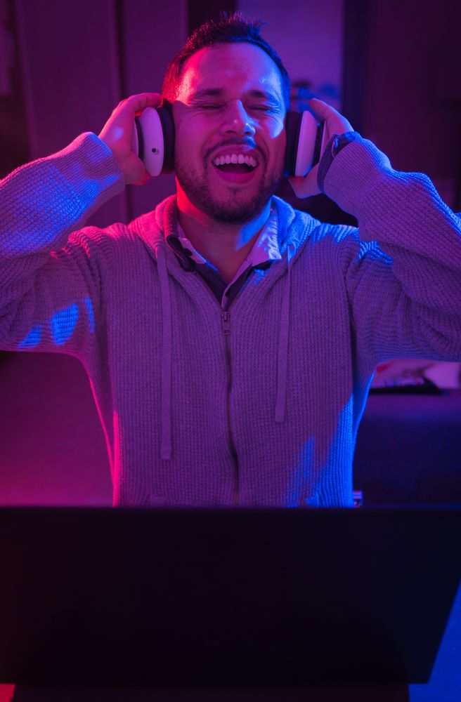 Man listening cheerfully to music with headphones.