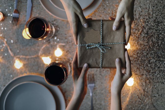 Aerial view of gift exchange over a set dinner table