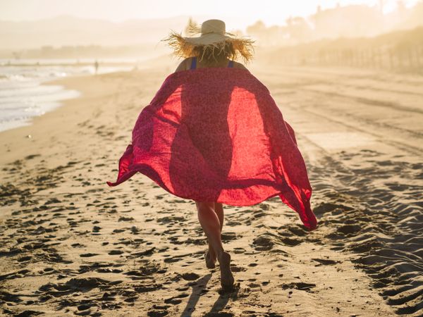 Woman with pink pareo on sandy beach