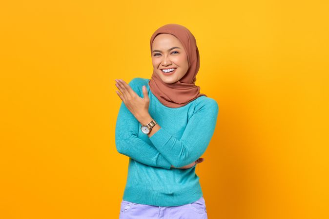 Muslim woman with arms crossed and hand gesturing to the side