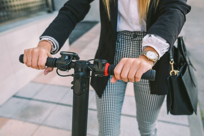 Unrecognizable businesswoman with e-scooter outdoors