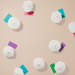 Aerial view of sun umbrellas and multicolored towels on sand