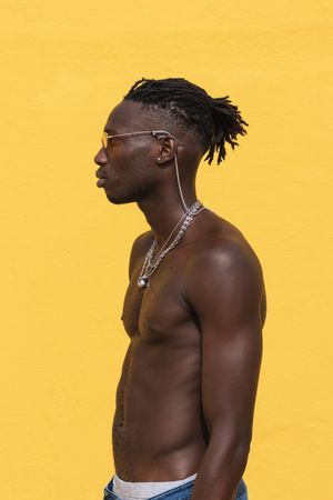 Serious Black man in trendy sunglasses near wall