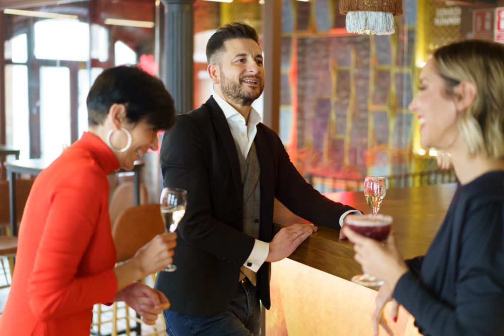 Friends laughing together with drinks at bar