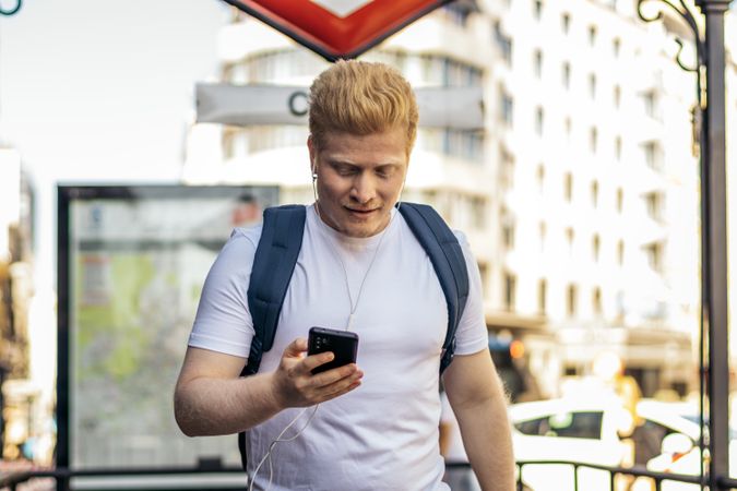 Latino man with albinism man using smartphone in the city
