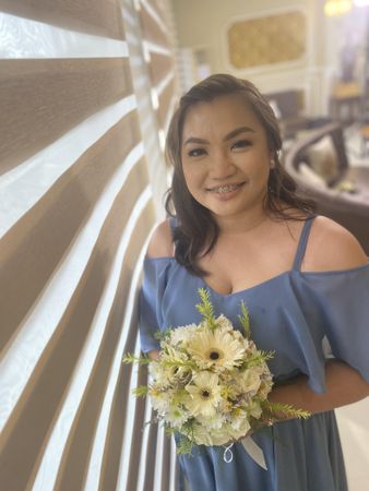 Bridesmaid in blue dress holding yellow flower bouquet