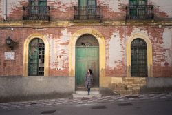 Woman on street with aged building