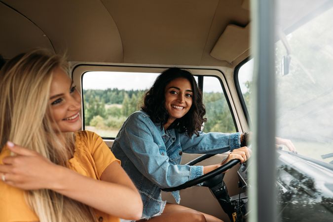 Young woman sitting on a driver seat in camper van