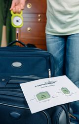 Woman checking luggage weight with steelyard balance