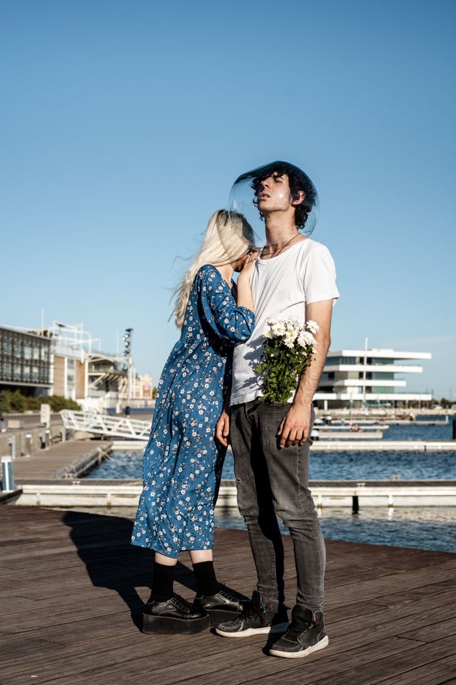 Woman hugging man with fish bowl on head
