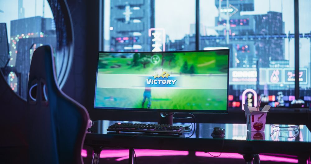 Empty Gaming Station with Video Game Victory Screen Display Standing on a Stylish Table in a Futuristic Cyberpunk Room with Neon Light.