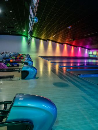 Multi-colored illumination of lanes in a huge bowling alley.