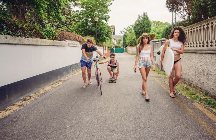 Happy young people having fun with skateboard and bicycle