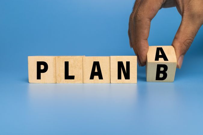 flip wooden blocks with plan a or b isolated on blue background. concept of business strategy planning