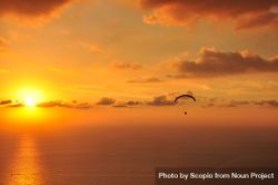 Silhouette of parachute flying over the sea during sunset 5pZLjb