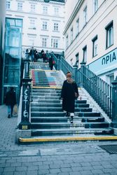 Back of woman ascending stairs to metro