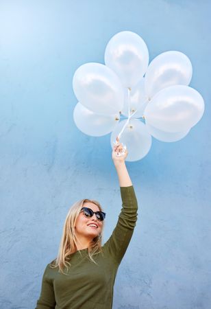 Happy young woman model with balloons