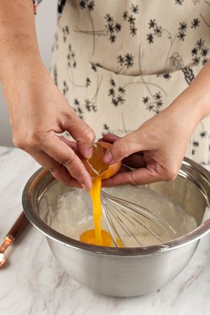 Woman Hands are Breaking Eggs for Baking on the Table