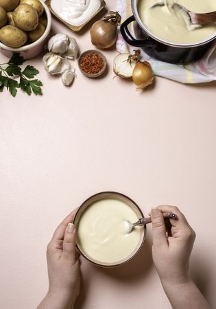 Woman hands eating cream soup