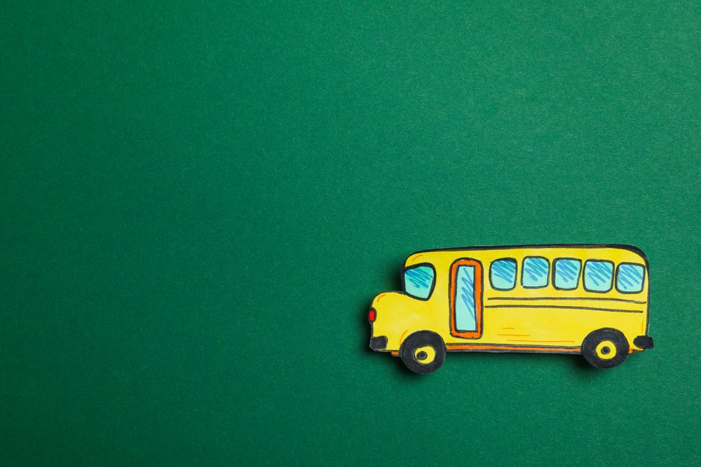 Decorative school bus on green background, space for text