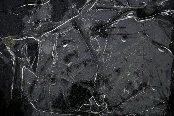 Fragment of thin ice on dark frozen river
