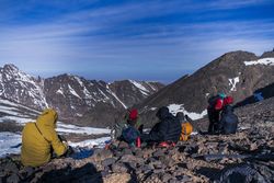 Mountaineers resting at tranquil mountain valley while hiking