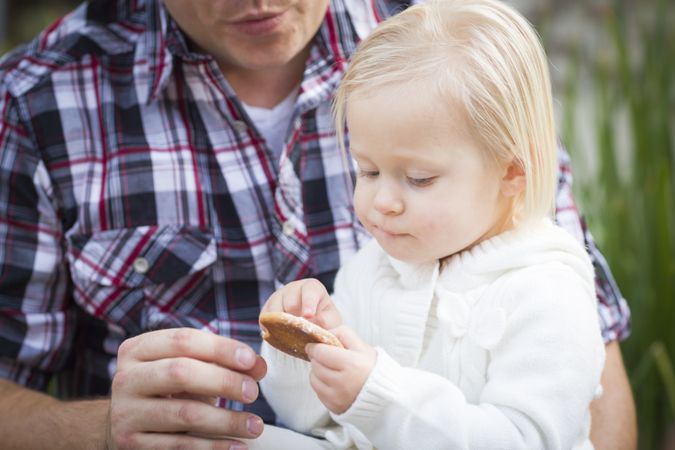 Adorable Little Girl Eating a Cookie with Daddy
