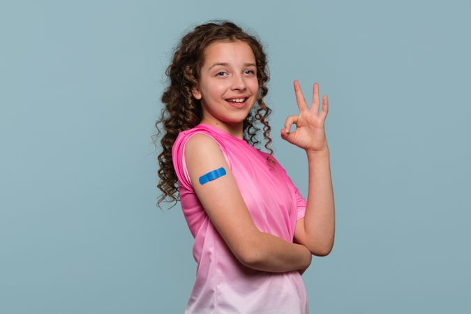 Smiling girl making an "OK" gesture