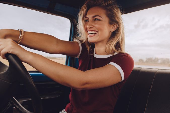 Smiling woman enjoying driving a car