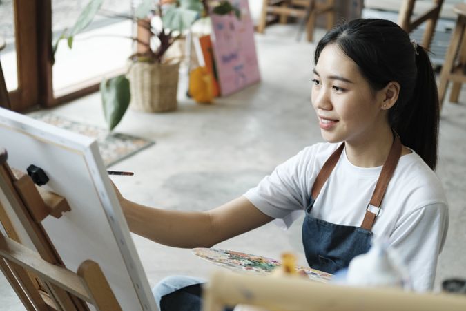 Crafting Inspiration. Female Artist Sketching and Painting in Workshop