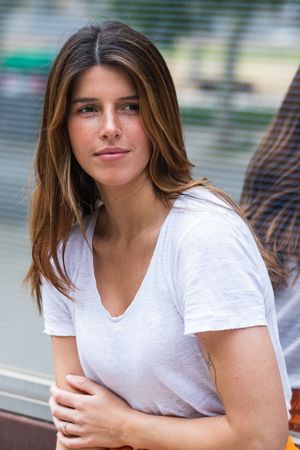 Woman standing near modern building wall on street