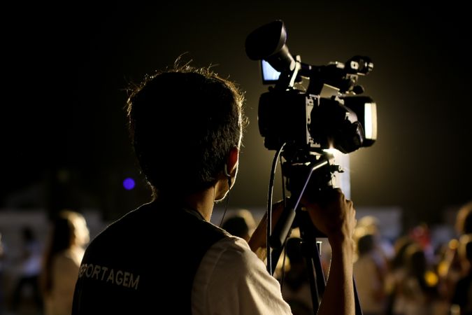 Back view of camera man shooting at a concert