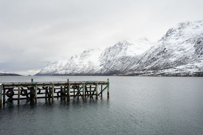 Wooden pier in middle of calm lake in winter