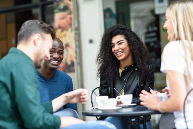 Group of smiling friends having a coffee together