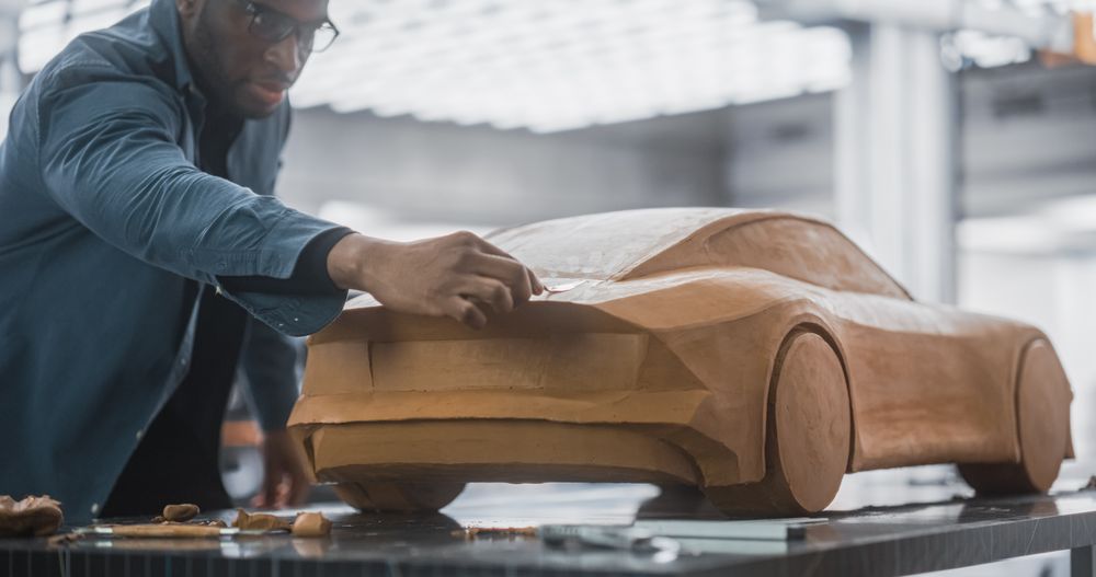 Portrait of a Black Creative Car Modeler Working on a Concept Car Made Out of Plasticine Modeling Clay.