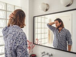 Handsome male checking hairstyle in mirror reflection
