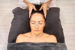 Young woman with cosmetic mask on face lying in beauty center