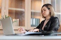 Asian Female manager working on project using computer laptop